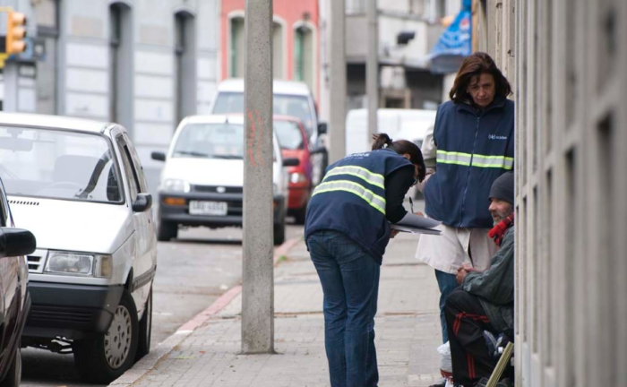 Vías de comunicación para dar aviso sobre personas en situación de calle Dos funcionarias del Ministerio de Desarrollo Social, de pie, dialogan con una persona sentada en la vereda